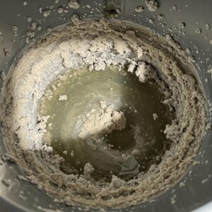 Close-up view of mineral sediment buildup inside a residential water heater tank.