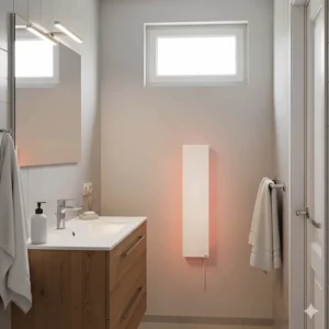 A slim, wall-mounted radiant panel heater warming a small bathroom, highlighting how this type of heater provides comfortable, quiet warmth.