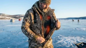 Graphic showing a heated jacket worn as a mid-layer under a heavy fishing bib for extreme cold.