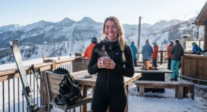 A smiling skier enjoying outdoor apres-ski activities without shivering, thanks to their battery heated body suit for skiing.